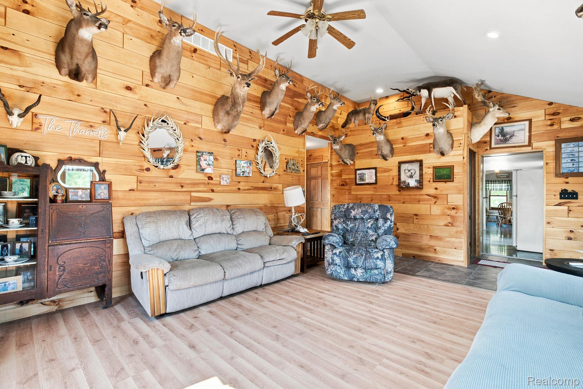 4201 Galbraith Line Road Croswell, MI 48422 - Photo 6 of 39 Vaulted ceiling featuring a ceiling fan, wood-finish flooring, wood paneling, and an entryway with tile flooring