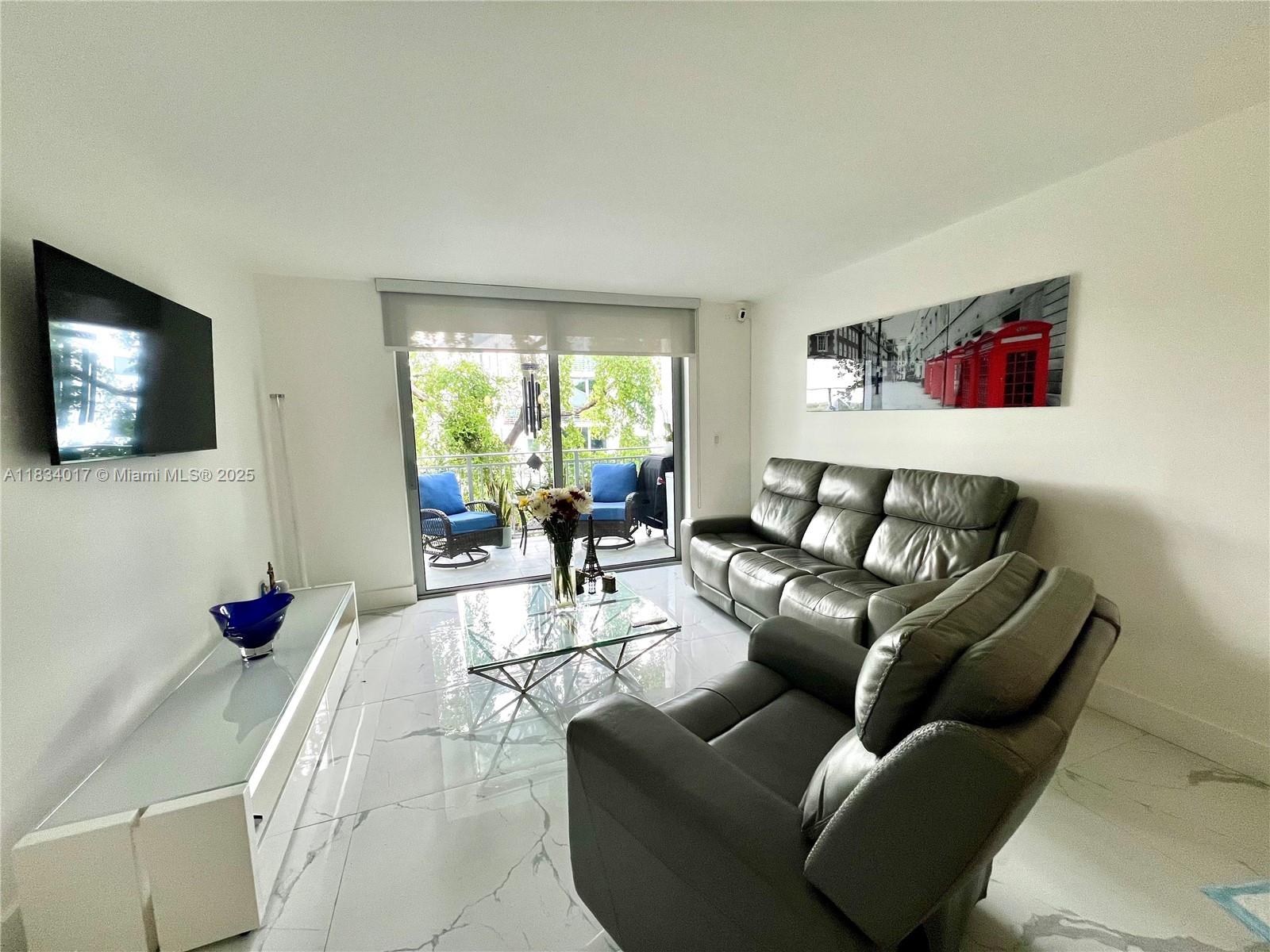 680 Northeast 64th Street, Unit A501 Miami, FL 33138 - Photo 13 of 30 a living room with furniture and a flat screen tv