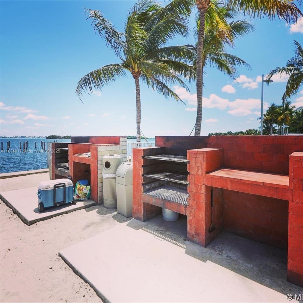 680 Northeast 64th Street, Unit A501 Miami, FL 33138 - Photo 24 of 30 a view of a backyard with a tub and palm trees
