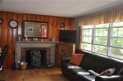 12 Colony Road Dennis Port, MA 02639 - Photo 4 of 12 a living room with furniture a fireplace and a flat screen tv
