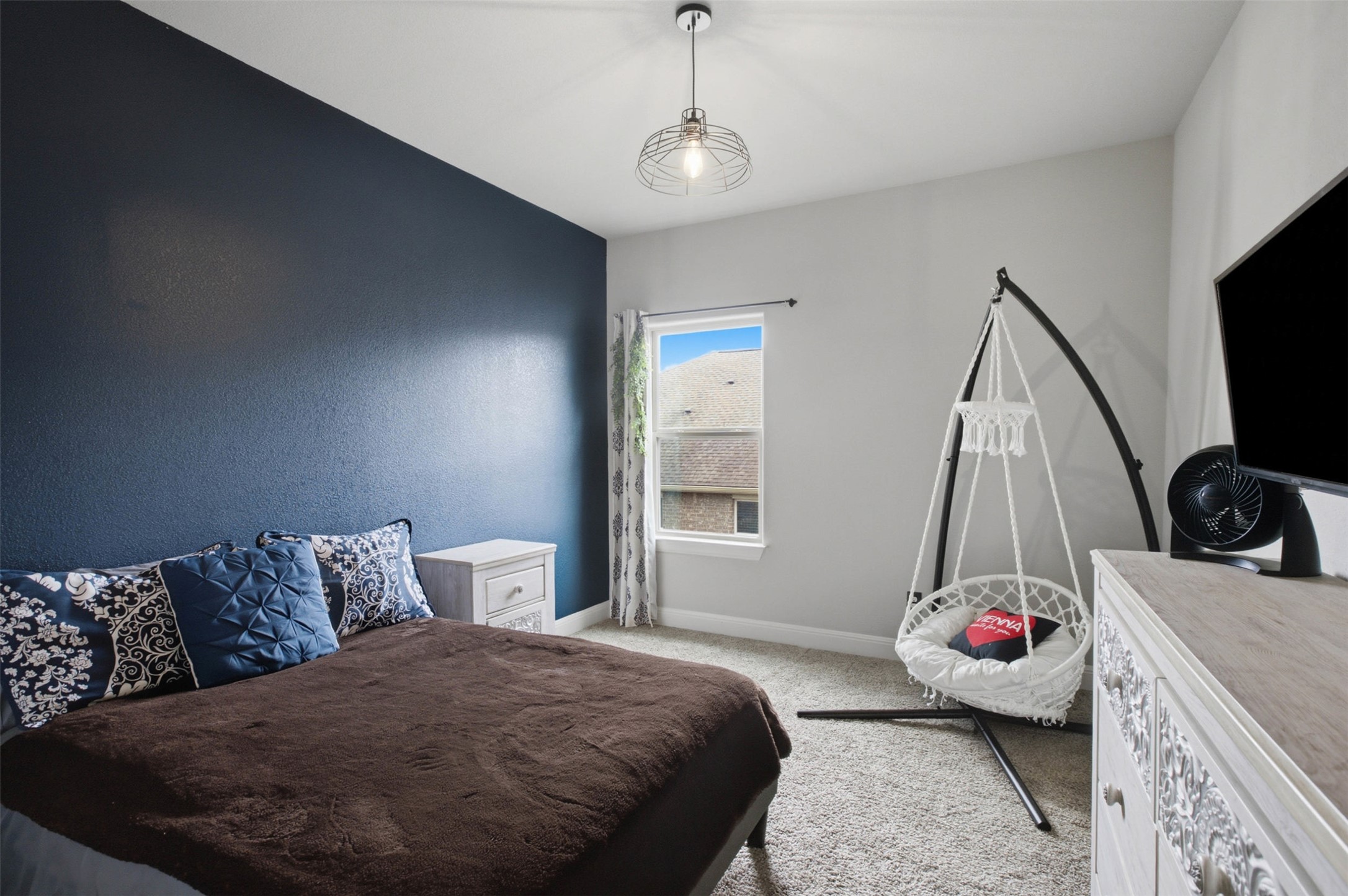 1113 Modoc Way Kyle, TX 78640 - Photo 23 of 34 A comforting bedroom space featuring soft carpeting and an inviting overhead light fixture.