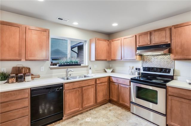 a kitchen with a sink stove top oven and cabinets