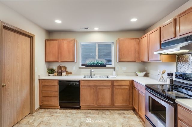 a kitchen with a sink stove top oven and cabinets