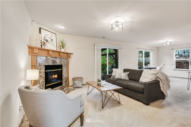 a living room with furniture a fireplace and a window