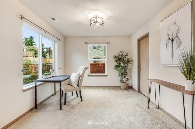 a view of a workspace with furniture and a window