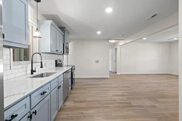 a kitchen with stainless steel appliances a sink stove and cabinets