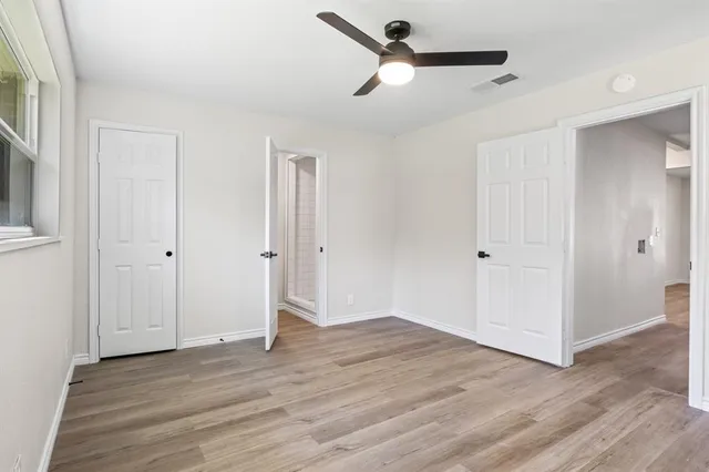 a view of empty room with wooden floor