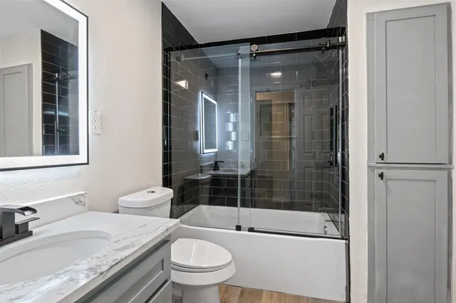 a bathroom with a granite countertop toilet sink and shower