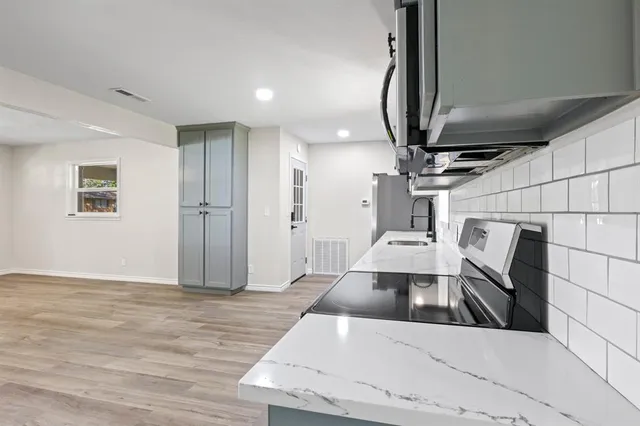 a view of an empty room with wooden floor