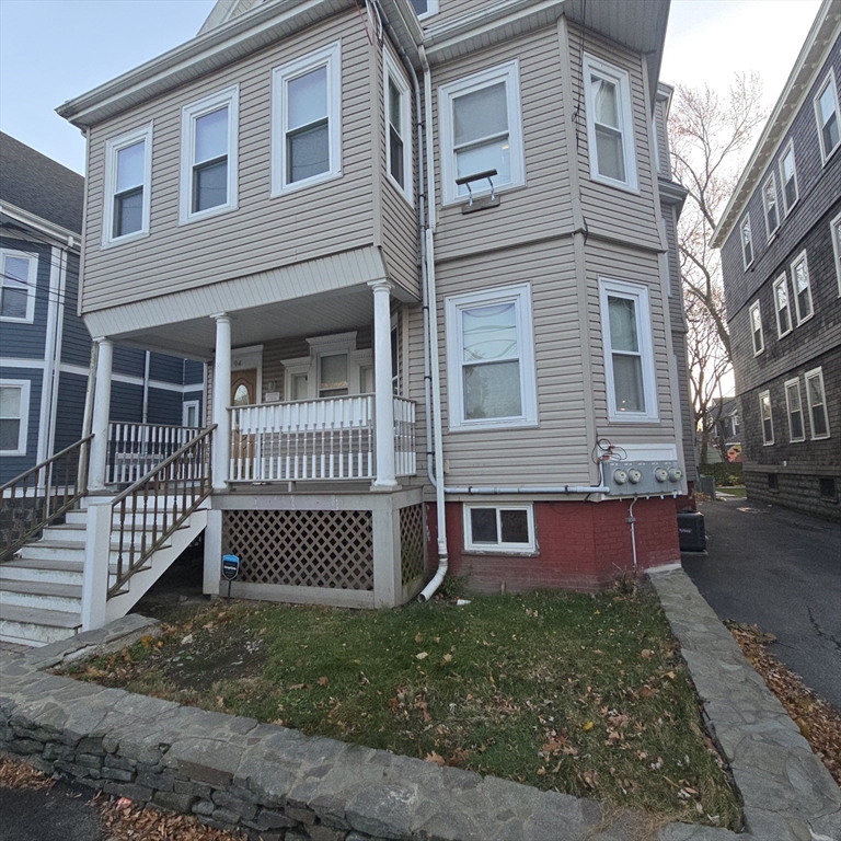 94 Morrison Avenue, Unit 3 Somerville, MA 02144 - Photo 11 of 12 a view of a brick house with a yard plants and wooden fence