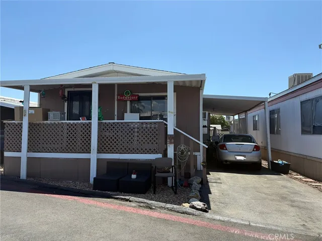 a view of a house with a barbeque and wooden stairs