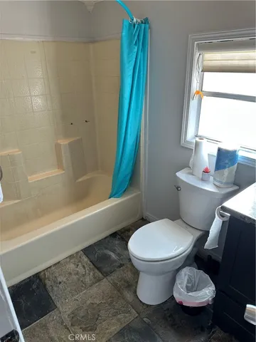 a white toilet sitting next to a bath tub