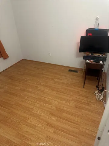 a view of workspace with wooden floor and fan