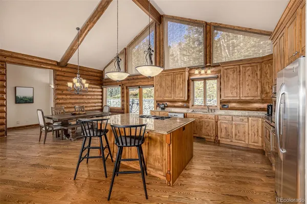 a kitchen with stainless steel appliances granite countertop a sink a stove and a wooden floors