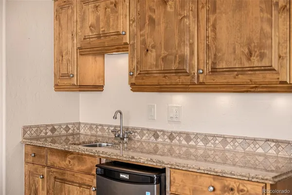 a bathroom with a granite countertop sink and a large mirror