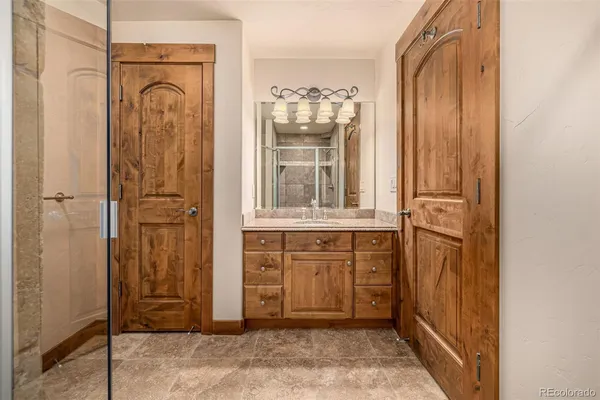 a bathroom with a granite countertop sink toilet mirror and a bathtub