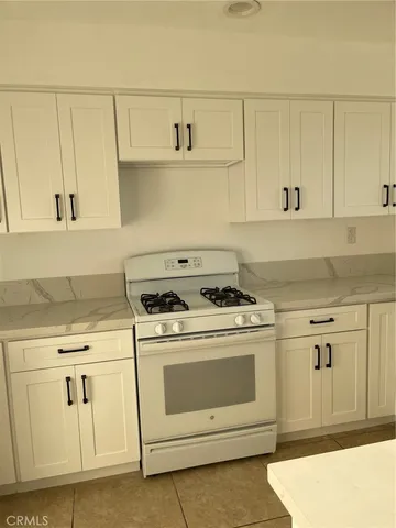 a kitchen with white cabinets and white appliances