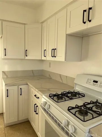 a kitchen with white cabinets and appliances