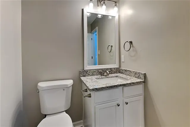 a bathroom with a toilet sink and mirror