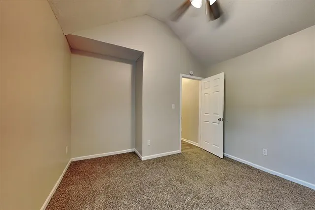 an empty room with closet and lamp on ceiling fan