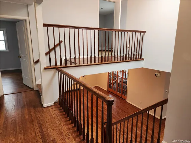 a view of staircase with railing and white walls