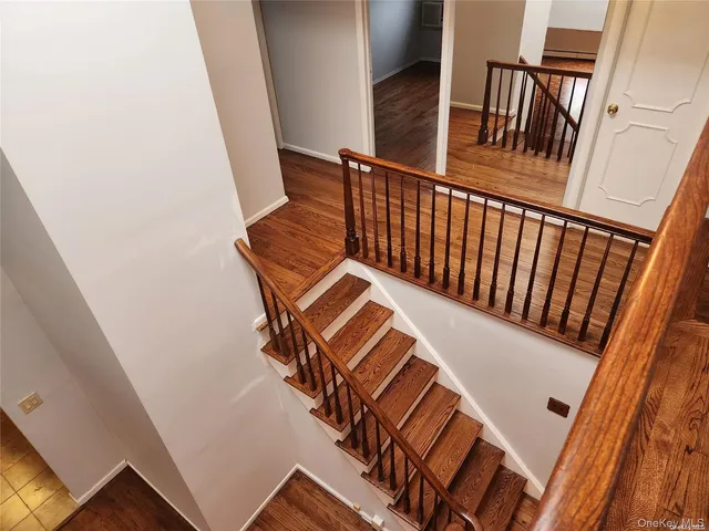 an empty room with wooden floor and a ceiling fan