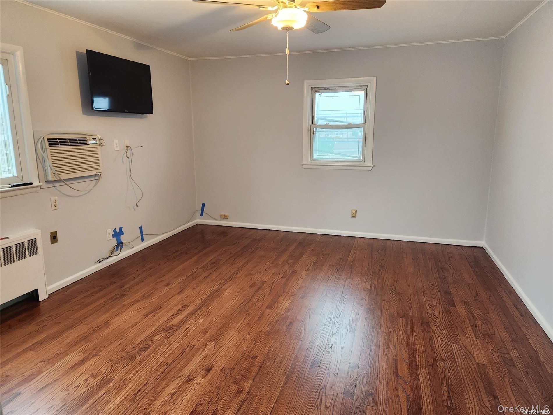3418 Oceanside Road Oceanside, NY 11572 - Photo 16 of 29 a view of room with wooden floor and flat screen tv