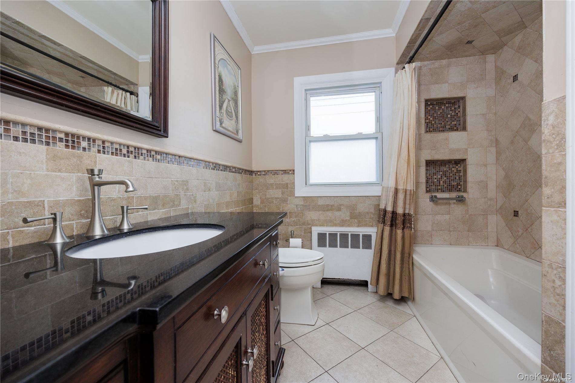 3418 Oceanside Road Oceanside, NY 11572 - Photo 20 of 29 a bathroom with a granite countertop sink a toilet a bathtub and shower