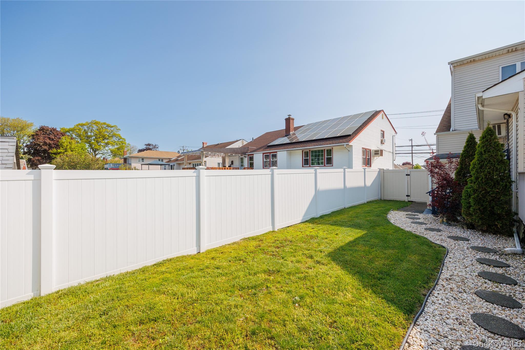 3418 Oceanside Road Oceanside, NY 11572 - Photo 25 of 29 a view of a house with a backyard and a garage