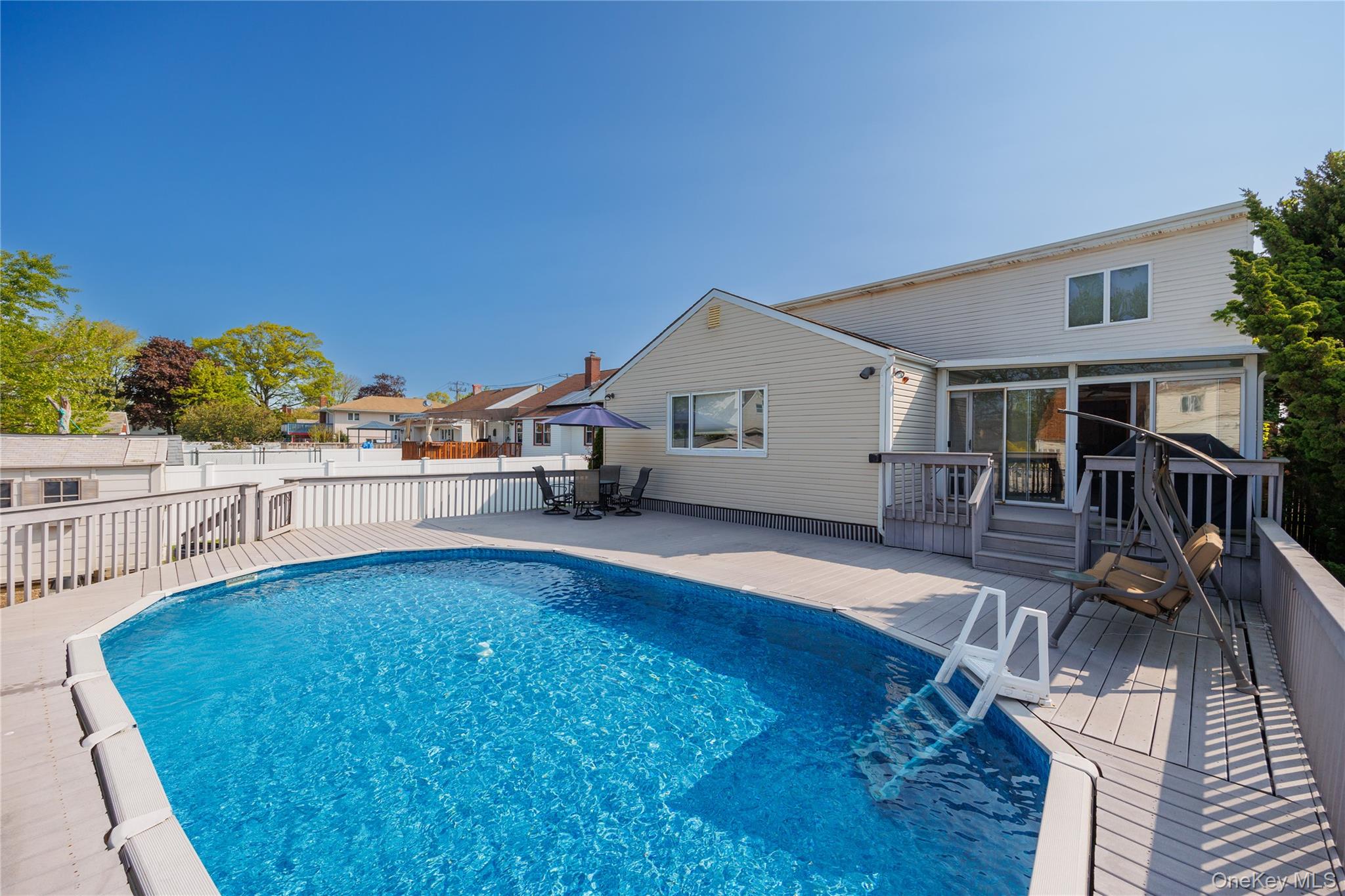 3418 Oceanside Road Oceanside, NY 11572 - Photo 27 of 29 a view of a house with pool and sitting area