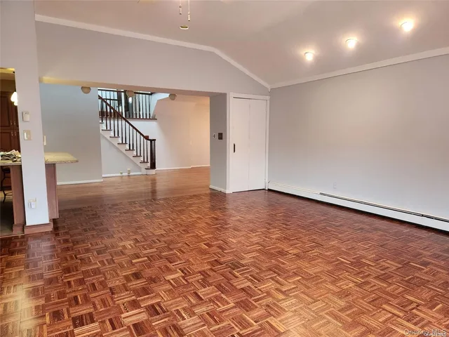 a view of empty room with wooden floor