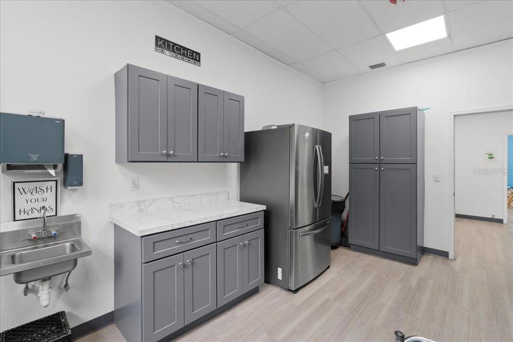 1938 Northeast Waldo Road Gainesville, FL 32609 - Photo 16 of 64 a kitchen with a refrigerator sink and cabinets
