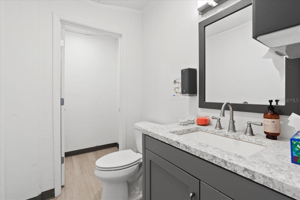 1938 Northeast Waldo Road Gainesville, FL 32609 - Photo 20 of 64 a bathroom with a granite countertop toilet sink and mirror