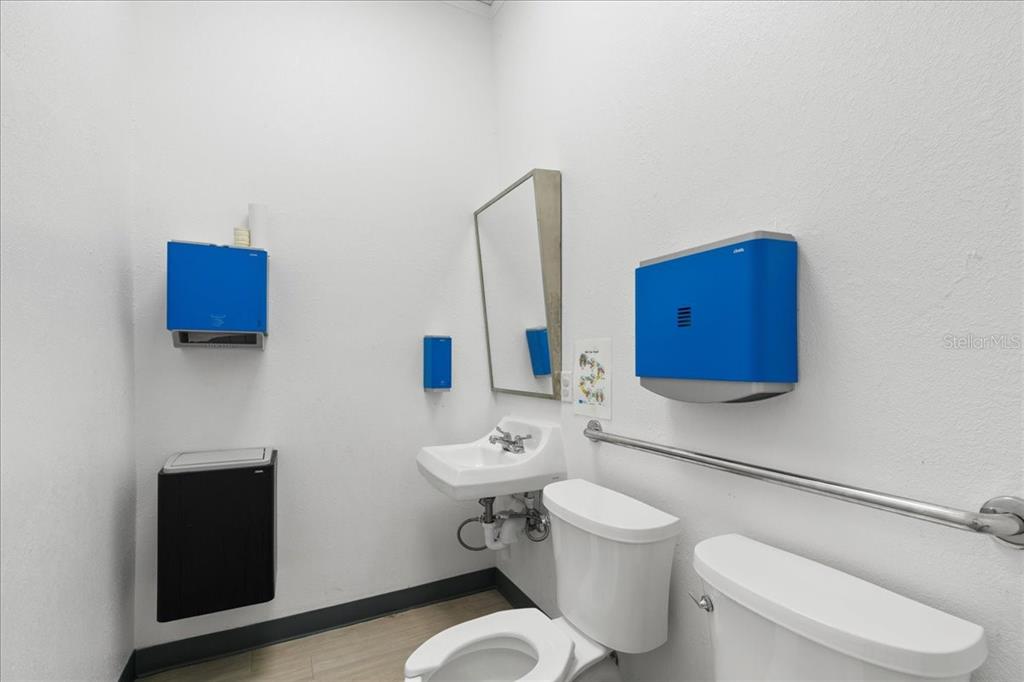 1938 Northeast Waldo Road Gainesville, FL 32609 - Photo 30 of 64 a bathroom with a toilet sink a mirror and shower