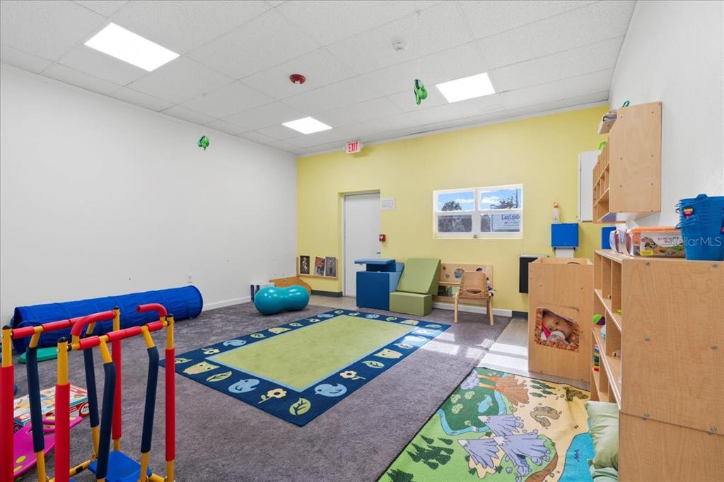 1938 Northeast Waldo Road Gainesville, FL 32609 - Photo 34 of 64 a living room with furniture and a baby crib