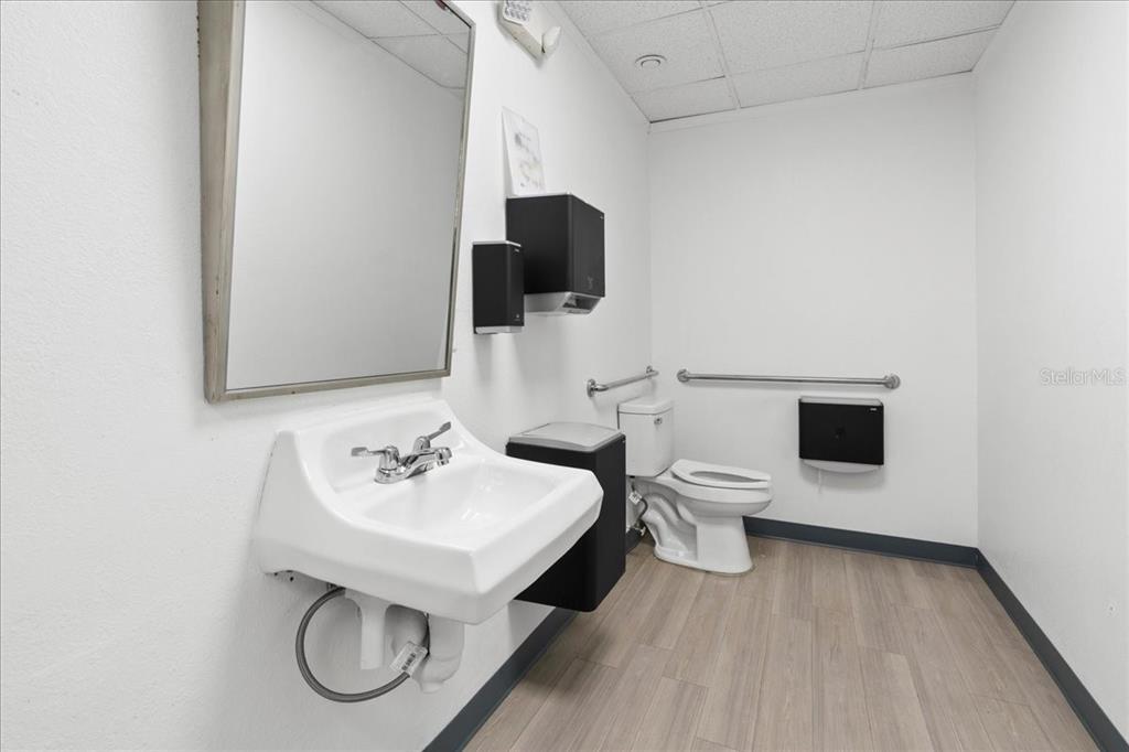 1938 Northeast Waldo Road Gainesville, FL 32609 - Photo 39 of 64 a bathroom with a sink a toilet and mirror