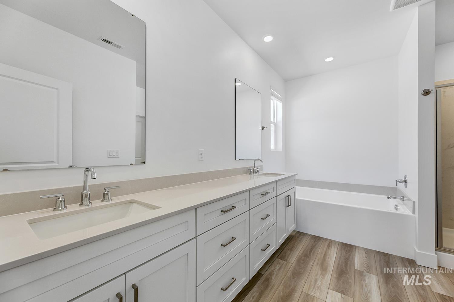 4548 West Wapoot Street Meridian, ID 83646 - Photo 14 of 17 Spacious bathroom featuring a double vanity with stone countertops, undermount sinks, and chrome fixtures