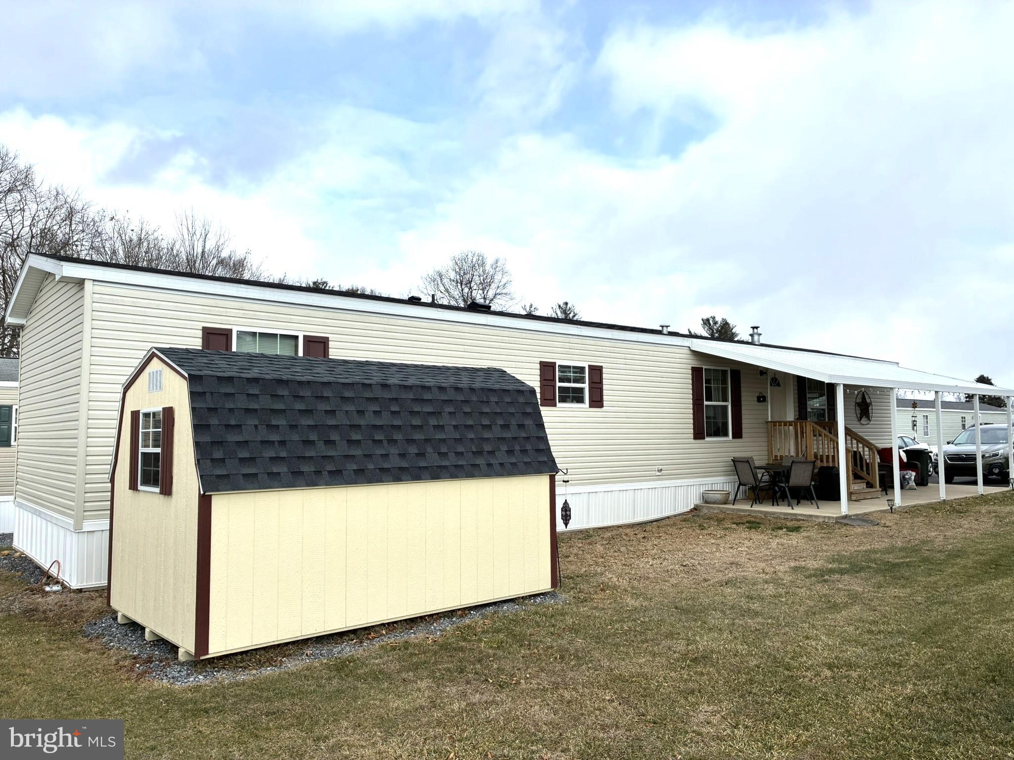 a view of a house with backyard and trees in the background