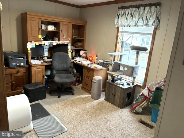 a view of a workspace with furniture and a window