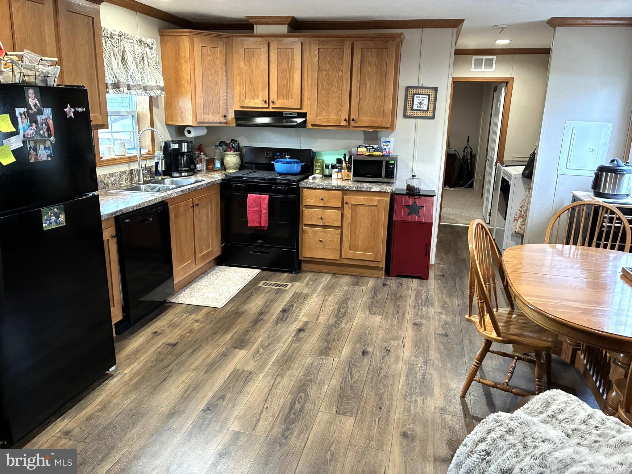 135 Hillside Lane Howard, PA 16841 - Photo 7 of 19 a kitchen with stainless steel appliances granite countertop a stove a sink dishwasher a microwave oven and a dining table with wooden floor