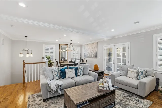 a living room with furniture or couches and a dining table with wooden floor