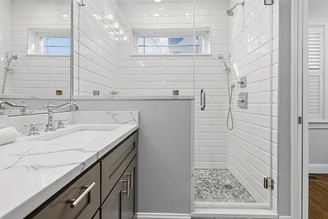 a bathroom with a granite countertop sink a toilet and shower