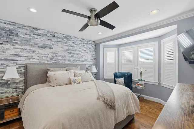 a bedroom with a large bed and wooden floor