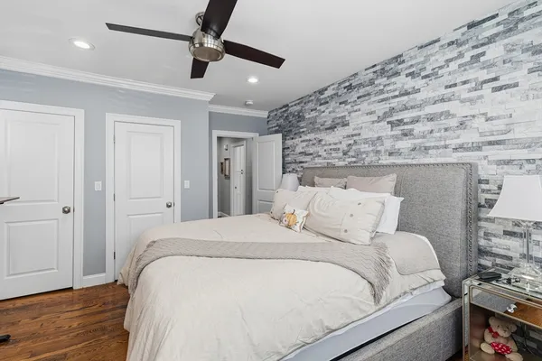 a bedroom with bed and wooden floor