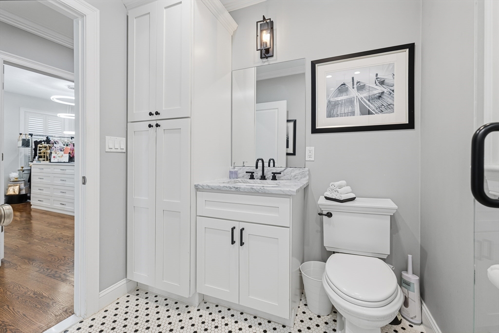 491 Washington Street, Unit 1 Braintree, MA 02184 - Photo 27 of 42 a bathroom with a toilet a sink and glass door
