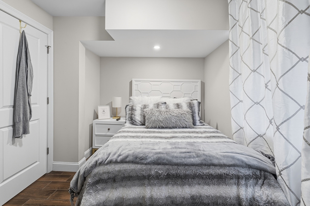 491 Washington Street, Unit 1 Braintree, MA 02184 - Photo 35 of 42 a bedroom with a bed and a white wall