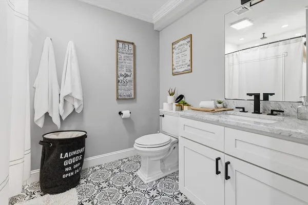 a bathroom with a granite countertop toilet sink and a mirror