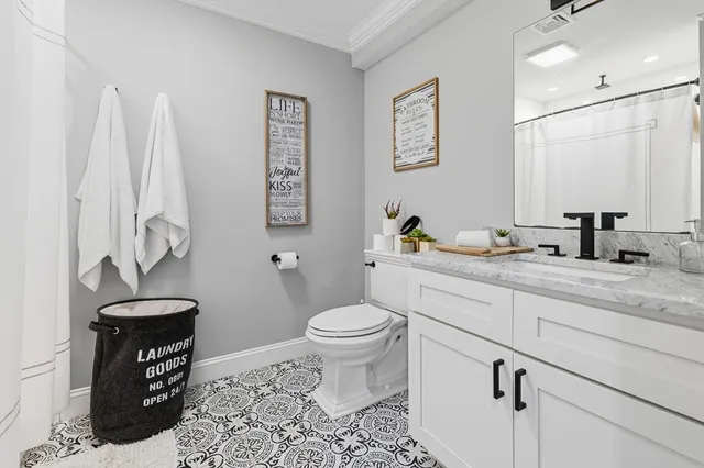 a bathroom with a granite countertop toilet sink and a mirror