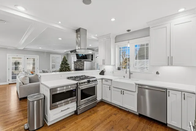 a kitchen with stainless steel appliances granite countertop a sink a stove and a wooden floors