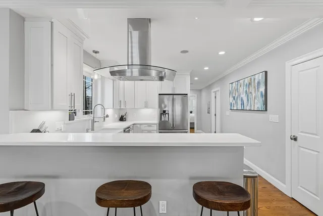 a kitchen with a sink a stove cabinets and a wooden floor